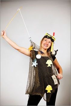 a woman in a costume holding a stick and wearing a hat with fish on it