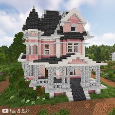 a large pink and white house sitting on top of a lush green field