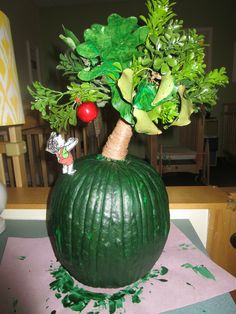 a green pumpkin shaped planter sitting on top of a table