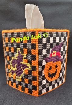 an orange and black basket with a tissue dispenser