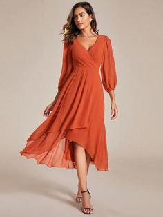 a woman is wearing an orange dress with long sleeves and a v - neckline