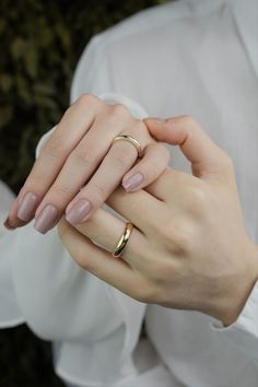 a woman holding onto her gold wedding ring