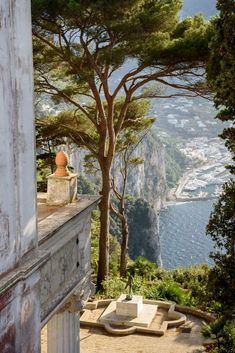 an old building overlooks the ocean and mountains