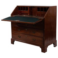 an old wooden desk with two drawers and a green felt pad on the bottom drawer