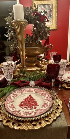 the table is set with red and gold plates