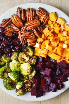 a white plate topped with brussel sprouts, brussels sprouts and sweet potatoes