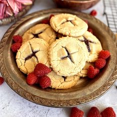 some cookies and raspberries are on a plate