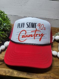 Take a trip down memory lane with this nostalgic "Play Some 90s Country" foam trucker hat! Perfect for fans of classic country music, this hat features a vibrant DTF (Direct to Film) print that captures the essence of the 90s country era. Whether you're at a concert, tailgate, or just running errands, this hat will keep you looking cool and feeling comfortable. **Key Features - **Premium Foam Trucker Hat Lightweight and breathable, perfect for all-day wear. - **"Play Some 90s Country" DTF Print High-quality, durable print that won't fade or peel. - **Stylish Hat Chain Removable chain adds a modern touch, easily taken off for a more classic look. - **Adjustable Snapback One size fits most, ensuring a comfortable fit. - **Personalization Available Add your name, initials, or favorite phrase Vintage Adjustable Trucker Hat With Letter Print, Retro Trucker Hat For Baseball Season Streetwear, Retro Red Trucker Hat With Letter Print, Retro Red Trucker Hat, Retro Snapback Hat For Baseball Season, Retro Trucker Hat For Baseball Season, Vintage 5-panel Trucker Hat For Baseball Season, Retro Snapback Trucker Hat For Festival, Vintage Adjustable Trucker Hat For Baseball Season