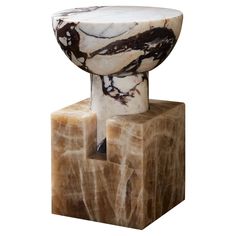 a marbled object on a wooden block with a white and black design in the middle