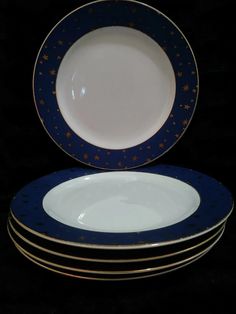 four plates stacked on top of each other with gold and blue trim around the edges