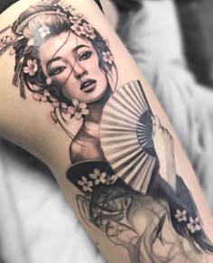 a woman with a fan tattoo on her thigh is shown in black and grey colors