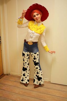 a woman dressed up as a cowgirl holding a drink in one hand and a cowboy hat on her head