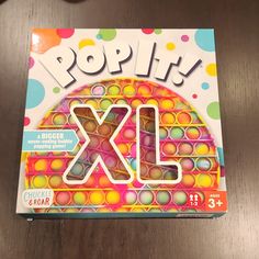 the front cover of a children's book called pop it xx, on a wooden table