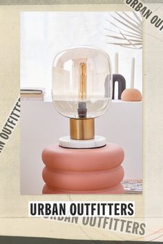 the urban outfitters light is on top of a round object with a gold base