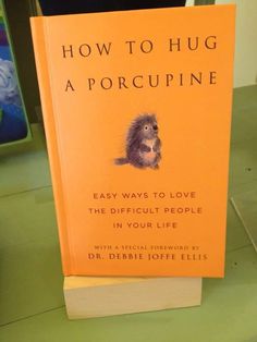 the book how to hug a porcupine is sitting on top of a table