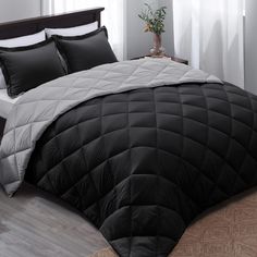 a black and white comforter on a bed in a room