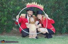 a man and woman dressed in costume posing for a photo with a baby inside a hula hoop