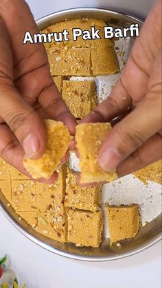 two hands holding pieces of food in front of a plate