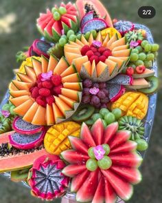 a bunch of fruit that are on top of a plate with watermelon, grapes and pineapples