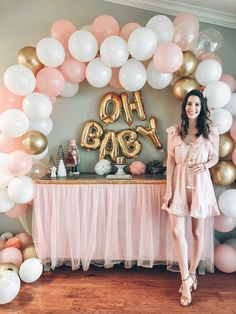 a woman standing in front of a table with balloons