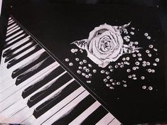 a drawing of a rose on top of a piano keyboard with skulls and beads around it