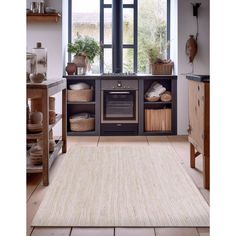 a kitchen area with an oven, counter and shelves filled with baskets on the floor