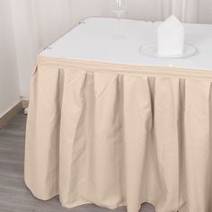 a table with a white cloth on it and a wine glass sitting on top of it