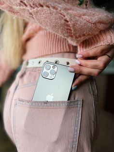 a woman is holding an iphone in her pocket and showing the back side of her pants