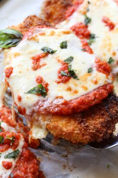 a piece of chicken parmesan is being lifted with a fork