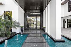 an indoor swimming pool with water features in the center and two large planters on either side