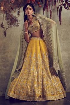 Mustard yellow lehenga with floral embroidery and drawstring at the waist. Comes with blouse and mint green dupatta.
Component: 3
Embroidered
Neckline: V-Neck
Sleeve Length: Half
Fabric: Raw Silk
Color: Yellow
Embroidered cutwork blouse and dupatta
Closure: 
Blouse: Concealed hook closure at front
Lehenga: Drawstring at the waist - Aza Fashions Mustard Yellow Lehenga, Embroidered Bridal Lehenga, Haldi Outfits, Jayanti Reddy, Raw Silk Lehenga, Black Lehenga, Organza Lehenga, Yellow Lehenga, Embroidered Lehenga