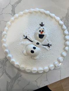 there is a frosted cake with two snowmen on it