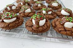 chocolate cookies with marshmallows and sprinkles on a cooling rack