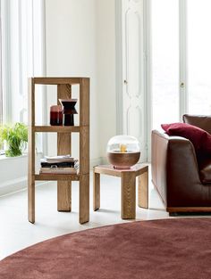 a living room filled with furniture and a brown chair in front of a large window