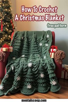 a green crochet christmas blanket sitting on top of a chair next to a tree