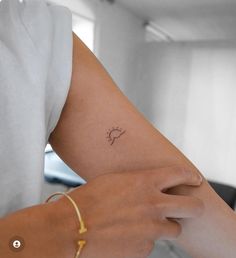 a woman's arm with a small tattoo on the left side of her arm