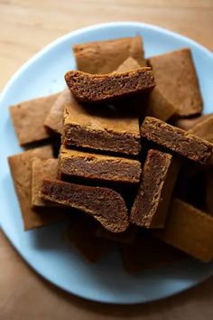 a plate full of brownie squares on a wooden table