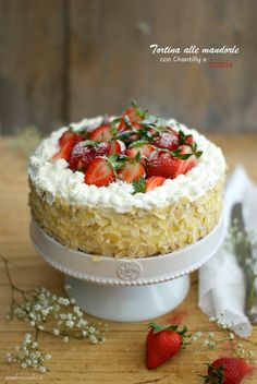 there is a cake with strawberries on the top and white frosting around it