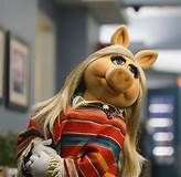 the miss piggy doll is wearing a striped shirt