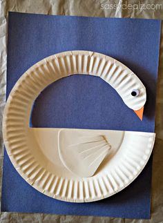 a paper plate shaped like a duck on top of a piece of blue paper with the shape of a circle