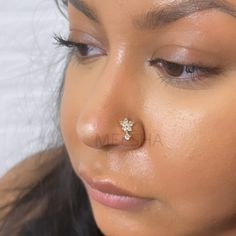 a close up of a woman with a nose piercing on her nose, looking at the camera