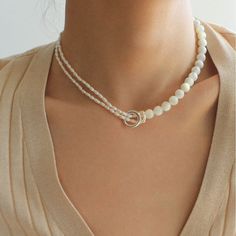 This stunning necklace features an elegant blend of 8mm natural white mother-of-pearl and delicate millet pearls, creating a chic half-and-half design that is both eye-catching and fashionable. With its sophisticated yet modern aesthetic, this piece brings an air of elegance and grace to any outfit. Whether paired with a dress, blazer, or knitwear, it adds a soft and refined touch, making it the perfect accessory for a variety of styles. Metal: Recycled Sterling Silver Plated On Brass Material: Freshwater Pearls/ 8mm White Mother-of-pearl Length: 330-390mm/33-39cm