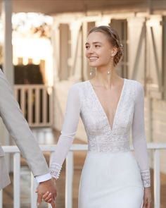 a bride and groom hold hands as they walk hand in hand