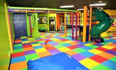 an indoor play area with colorful tiles and slides