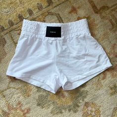 a pair of white shorts sitting on top of a carpet