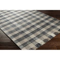 a gray and white checkered rug on a wooden floor