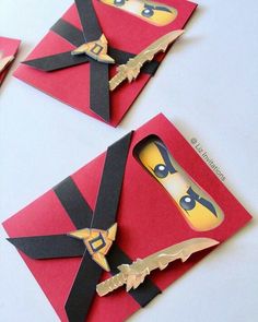 three pieces of paper cut out to look like ninjas on red envelopes with gold accents