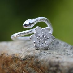 I am discontinuing this item so grab it while you can. Too many cheap copies out there. - Multi Petal Lotus Design - Sterling Silver 925 Flower measures 10mm across Adjustable size from size 4 and up - if you would like me to adjust the ring before sending it to you, just message me at time of purchase with your ring size. This ring turned out so well. The band looks like a tree branch with a flower bud and a flower in full bloom. These have a lovely textured finish. This is stunning on! Lotus Symbolism The flower always looks so clean and pure against the background of the dirty pond. Because of this the lotus flower has come to be associated with purity and beauty in the religions of Buddhism and Hinduism respectively; the ancient Egyptians scholars observed that in the night-time the lo Luxury Handmade Sterling Silver Flower Ring, Lotus Ring Silver, Sterling Silver Spiritual Flower Ring, Sterling Silver Lotus Flower Jewelry In Silver, Silver Lotus Flower Necklace, Lotus Symbol, Lotus Flower Ring, Lotus Ring, Flower Band