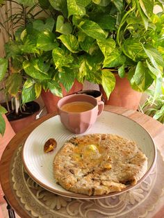 there is a plate with some food on it and a cup of tea next to it