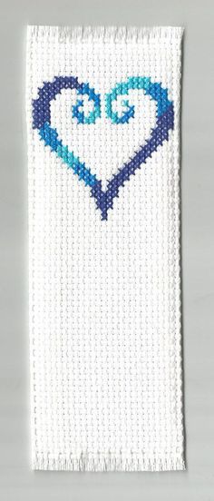 a white and blue beaded piece with a heart on it